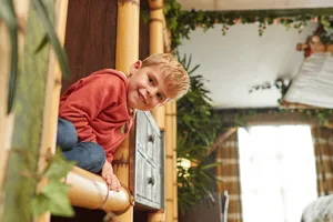 Child peeking round a corner inside a Penguin themed room