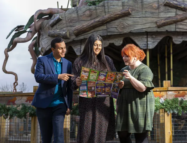 Three people looking Chessington World of Adventures Resort map