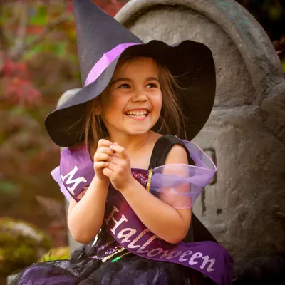 Little Girl dressed in a purple and black witch outfit