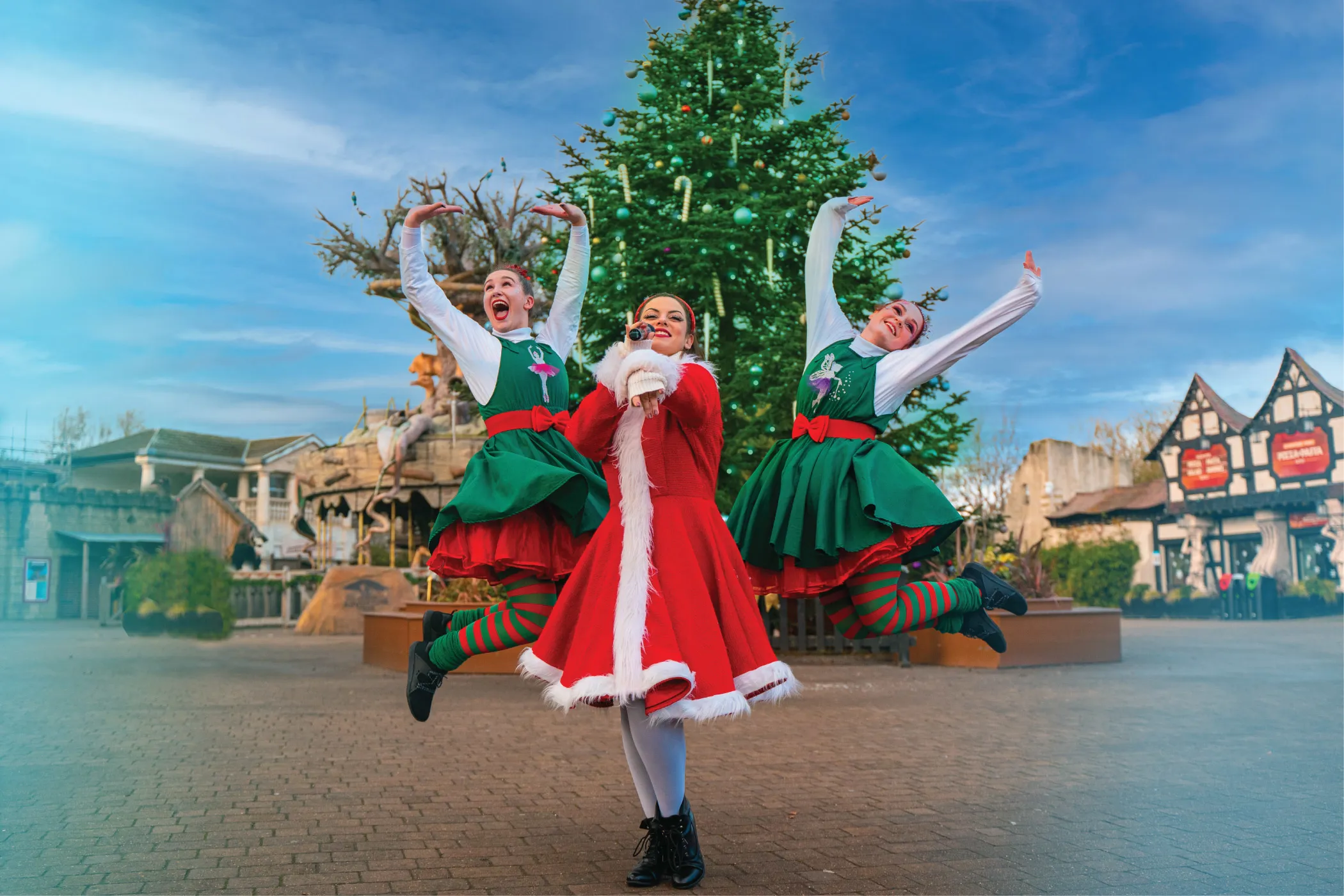 Elves jumping in front of Christmas Tree 